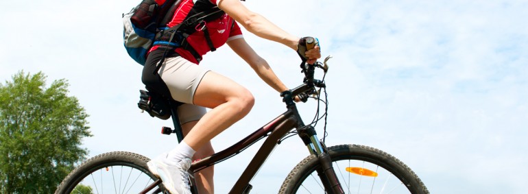 Happy Young Woman riding bicycle outside. Healthy Lifestyle